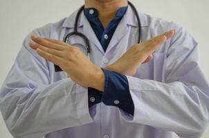 läkaren lyfte upp handen för att stanna hemma för att förhindra smittspridning. distans socialt koncept. foto