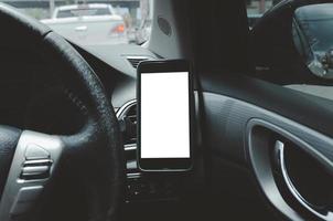 mobiltelefon på bilens luftventil. tomt med vit skärm. hämta smart telefon i bilen. foto
