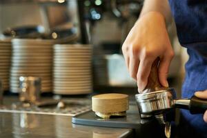 stänga upp av Barista kvinna händer brådskande kaffe in i manipulera, förbereder beställa i Kafé Bakom disken foto