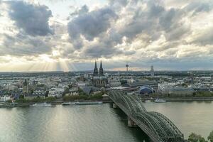 dramatisk storm moln över cologne katedral och hohenzollern bro i de solnedgång foto