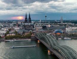 dramatisk storm moln över cologne katedral och hohenzollern bro i de solnedgång foto