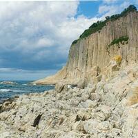 kust av kunashir ö på cape stolbchaty med basalt kolumnerad stenar foto