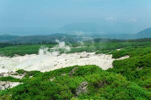 fumarole fält på de backe av mendeleev vulkan på kunashir ö utsikt de hav i de dis foto