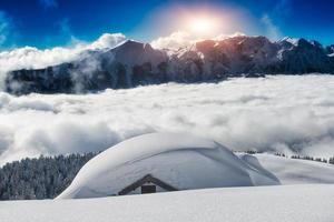 hus täckt med snö i de höga bergen foto