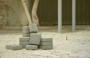 små lugg av grå gångväg plattor liggande i stack utomhus. material för stenläggning plattor förbi mosaik- i framsteg. kullersten installation foto