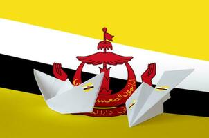 brunei darussalam flagga avbildad på papper origami flygplan och båt. handgjort konst begrepp foto