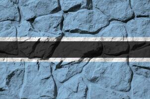 botswana flagga avbildad i måla färger på gammal sten vägg närbild. texturerad baner på sten vägg bakgrund foto