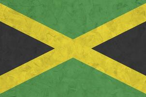 jamaica flagga avbildad i ljus måla färger på gammal lättnad putsning vägg. texturerad baner på grov bakgrund foto