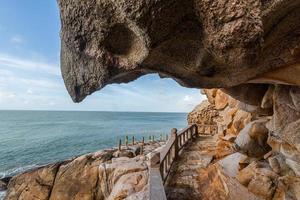 stenar av olika former vittrade av havet under den blå himlen foto