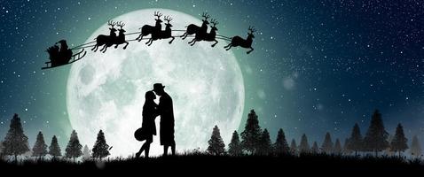 silhuett av jultomten på natten jul med par dans under fullmåne. foto