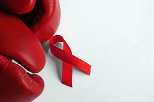 de röd boxning handskar och band isolerat på vit, symboliserar de bekämpa mot AIDS eller hiv. foto