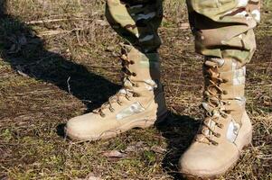 soldat i kamouflage byxor och armén stövlar. foto
