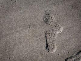 sulor av skor på svart sand foto