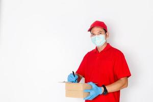 en leveransman som bär en röd klänning håller i en paketlåda. foto