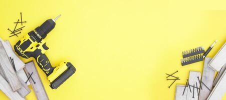 de gul-svart skruvmejsel på en gul bakgrund, skruvar, en uppsättning av bitar. foto