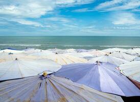 stort paraply trångt längs cha-am stranden foto