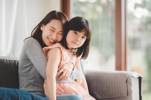 glad asiatisk mamma och söt liten dotter som har kul foto