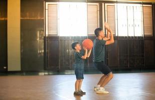 asiatisk familj som spelar basket tillsammans. lycklig familj som spenderar ledig tid tillsammans på semester foto