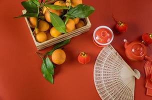 månens glada kinesiska nyårsfirande med ceremoni te på mandarin apelsiner en röd bakgrund