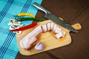 bacon remsor och chili paprikor på trä- skärande styrelse foto