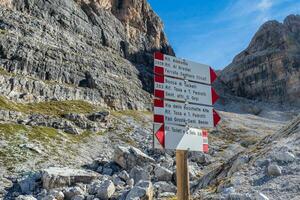 vandring riktning indikatorer. turist banor vägbeskrivning och resa tid visad på en traditionell riktning tecken på de dolomiti berg, Italien foto