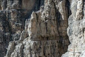 manlig berg klättrare på en via ferrata i hisnande landskap av dolomiter bergen i Italien. resa äventyr begrepp. foto