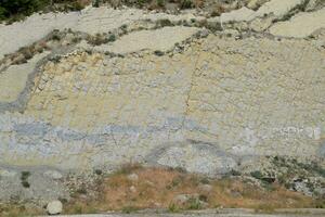 backe av de berg med skikten av sedimentär rocks. vertikalt belägen sedimentär stenar på kollaps sluttning. foto