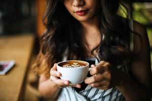 porträtt asiatisk kvinna leende slappna av i caféet foto