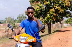 ung upphetsad afrikansk motorcyklist pekande foto