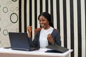 ung skön afrikansk sekreterare känsla upphetsad handla om Vad hon fick syn på på henne bärbar dator foto