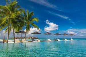 fantastisk landskap, simning slå samman blå himmel med moln. tropisk tillflykt hotell i maldiverna. fantastisk koppla av och fredlig vibrafon, stolar, solstolar under paraply och handflatan löv. lyx resa semester foto