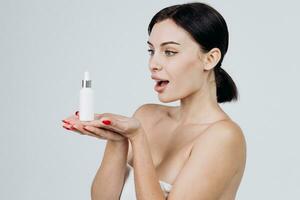 närbild skön kvinna med perfekt hud håll attrapp rör ansikte serum för hudvård behandling produkt reklam. produkt varumärke, företags- identitet och förpackning inspiration. foto