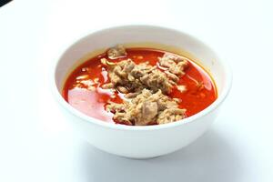 thai mat, kryddad röd curry med fläsk på vit bakgrund foto