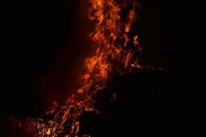 brinnande av ris sugrör på natt. röd brand på en svart bakgrund. förbränning. foto