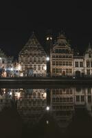 medeltida byggnader på graslei gata i de Centrum av Gent förbi de flod leie under de natt. Belgiens mest känd historisk Centrum. Gent vid vatten under midnatt foto