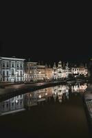 medeltida byggnader på graslei gata i de Centrum av Gent förbi de flod leie under de natt. Belgiens mest känd historisk Centrum. Gent vid vatten under midnatt foto