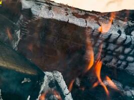 närbild av en brand med ved, kol och aska. foto
