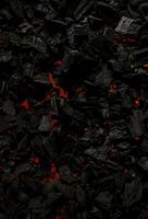 svart träkol med röd ränder av värme. svart texturerad bakgrund. foto
