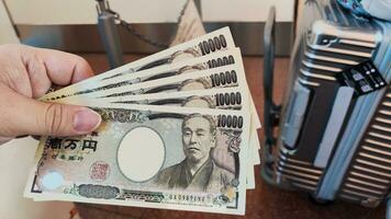 en hand innehav fem japansk Bank anteckningar foto