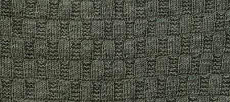 bakgrund med grå stickat blad form, stickning mönster med kablar. topp se, närbild. handgjort stickning ull foto