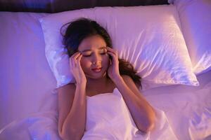 natt sovrum. deprimerad kvinna tyvärr om på de säng i de sovrum. ledsen asiatisk kvinnor lidande depression sömnlöshet vaken och sömn ensam på de säng i sovrum. depression hälsa människor begrepp. foto