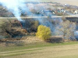 brinnande torr gräs längs de bevattning kanal. rök och de flamma av torr gräs. bränd torr gräs. foto