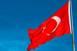 vinka turkiska flagga på blå himmel bakgrund. nationell högtider av turkiye foto