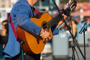 gata artist spelar gitarr i en fyrkant av en stad. foto