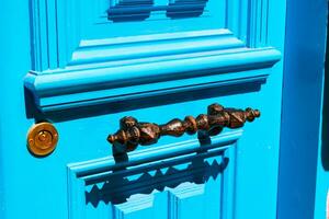 en rostig metall hantera av blå eller turkos dörr. foto