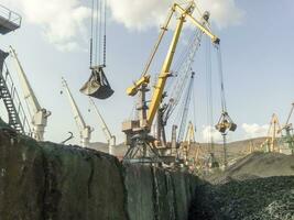 frakt industriell hamn, hamn kranar. läser in av antracit. transport av kol. högen av kol foto