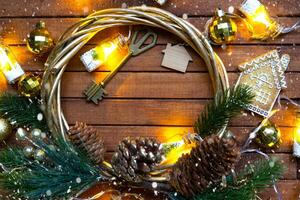 nyckel till hus med Nyckelring på mysigt brun trä- bakgrund med jul dekor layout. gåva för ny år, jul. byggnad, projekt, rör på sig till ny hus, inteckning, hyra och inköp verklig egendom foto