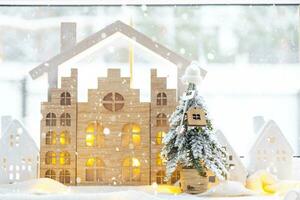 nyckel på jul träd och mycket liten hus på mysigt Hem med jul dekor på tabell av festlig vit kök. gåva för ny år. försäkring, rör på sig till ny hus, inteckning, hyra och verklig egendom foto