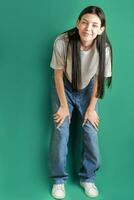 full längd porträtt av en ung flicka i en vit t-shirt och jeans. foto