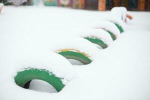 däck täckt med snö i en barns lekplats i vinter. foto